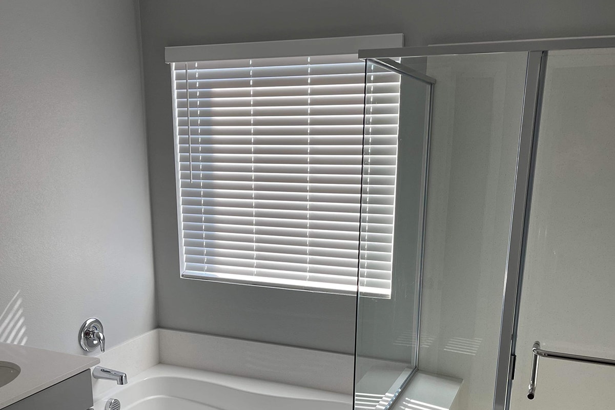 Installer fitting a custom shade in a luxury Southwest Florida home